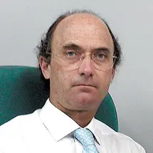 Prof. Basterra mit weißem Hemd und hellblauer Krawatte vor grauem Hintergrund.