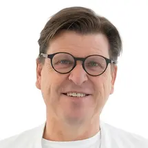 Torstein R. Meling, MD, wearing glasses and a white doctor's coat against a white background.
